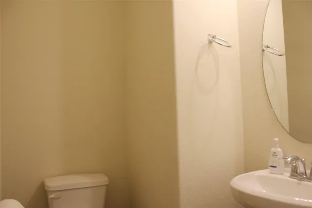 a bathroom with a sink a toilet and a mirror