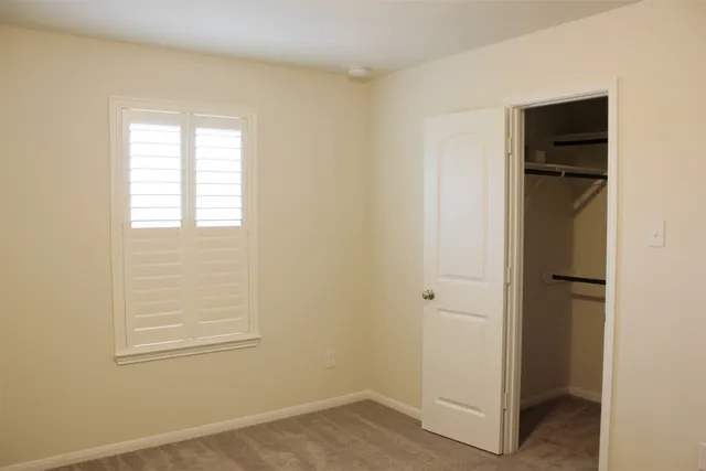 an empty room with windows and closet