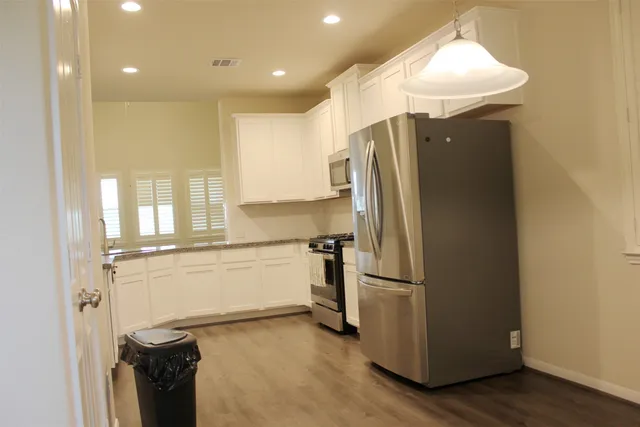 a kitchen with stainless steel appliances a refrigerator and a stove top oven