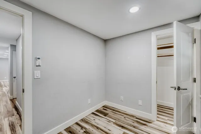 a view of a hallway with wooden floor and closet area