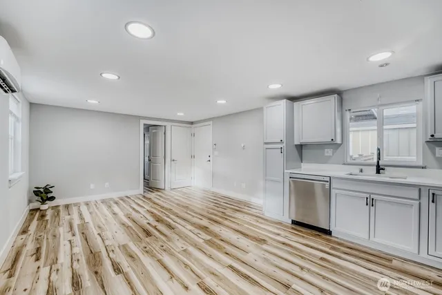 a open kitchen with kitchen island white cabinets and stainless steel appliances