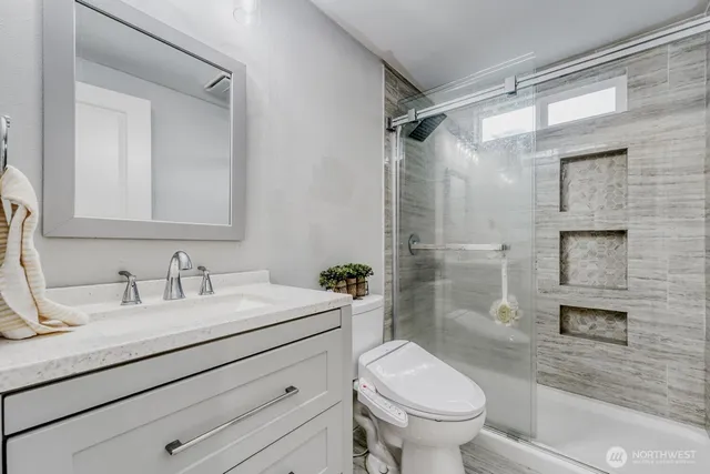 a bathroom with a sink a toilet and shower