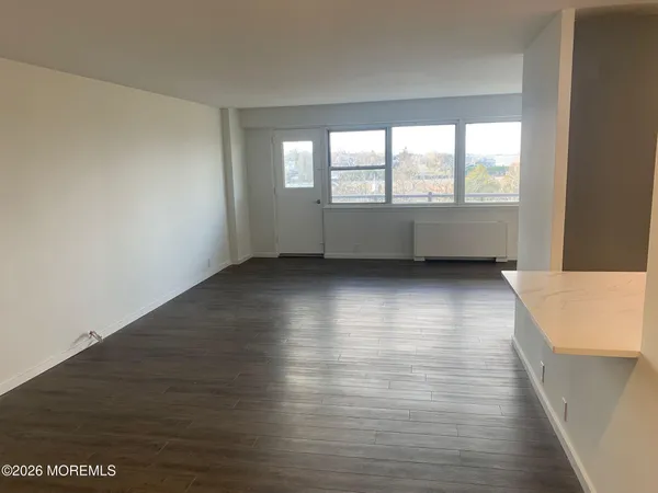 an empty room with wooden floor and entrance