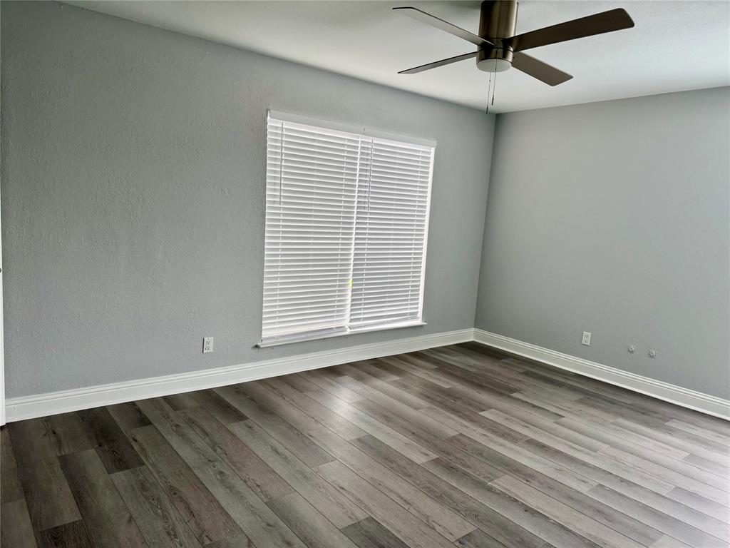 12818 Midway Road, Unit 1089 Dallas, TX 75244 - Photo 12 of 18 an empty room with wooden floor fan and windows