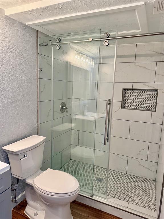 12818 Midway Road, Unit 1089 Dallas, TX 75244 - Photo 16 of 18 a bathroom with a toilet and a shower