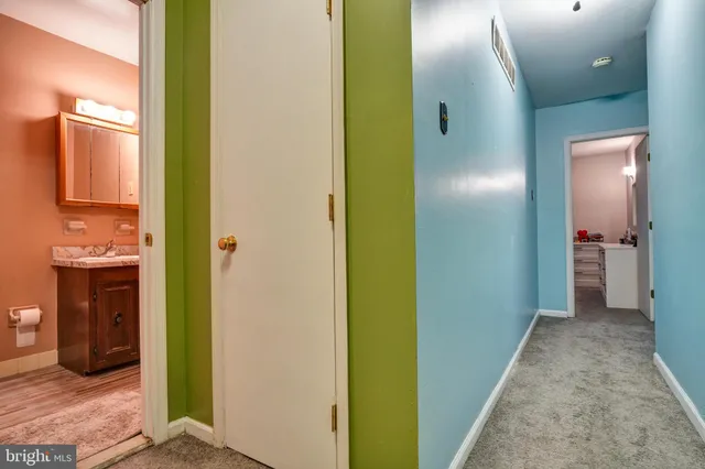 a view of a hallway with wooden floor and closet