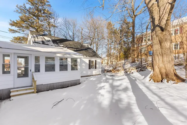 a view of a house with a yard covered in snow