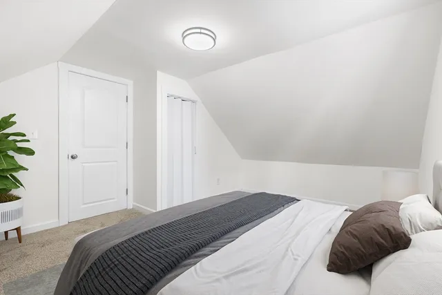 a bedroom with a bed and a potted plant