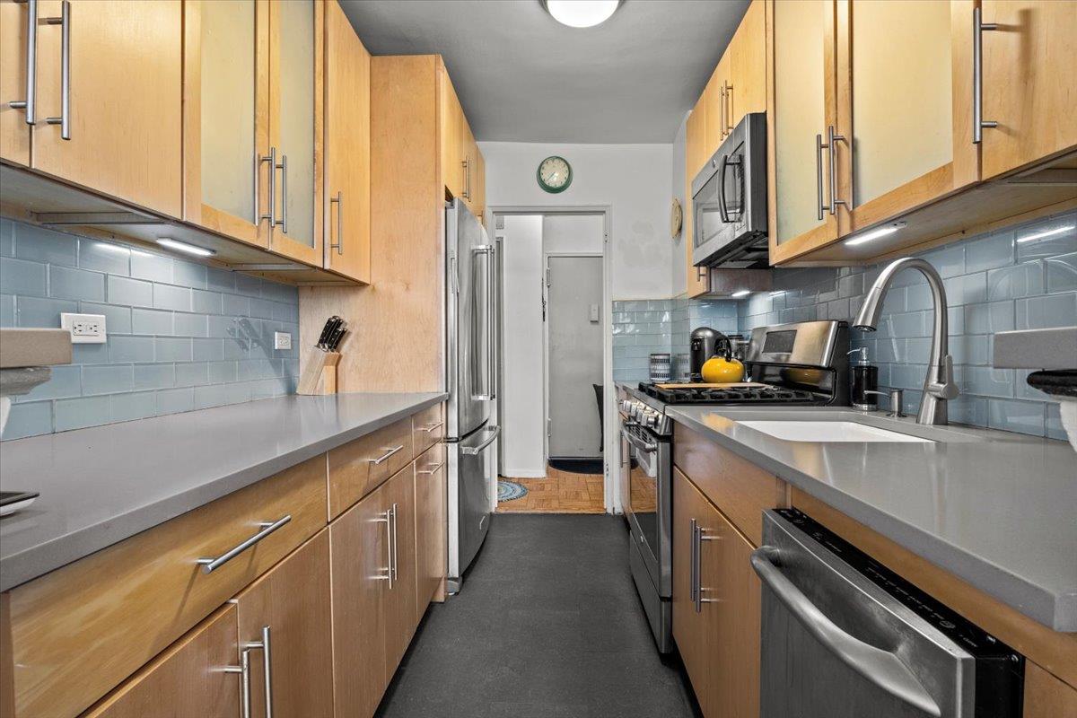 5550 Fieldston Road, Unit 7C Bronx, NY 10471 - Photo 8 of 26 a kitchen with stainless steel appliances granite countertop a sink and cabinets
