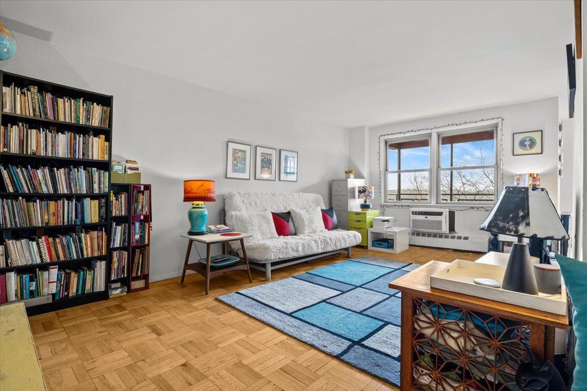 5550 Fieldston Road, Unit 7C Bronx, NY 10471 - Photo 9 of 26 a living room with furniture and a book shelf