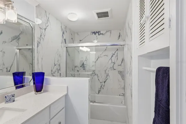 a bathroom with a bathtub sink vanity and shower