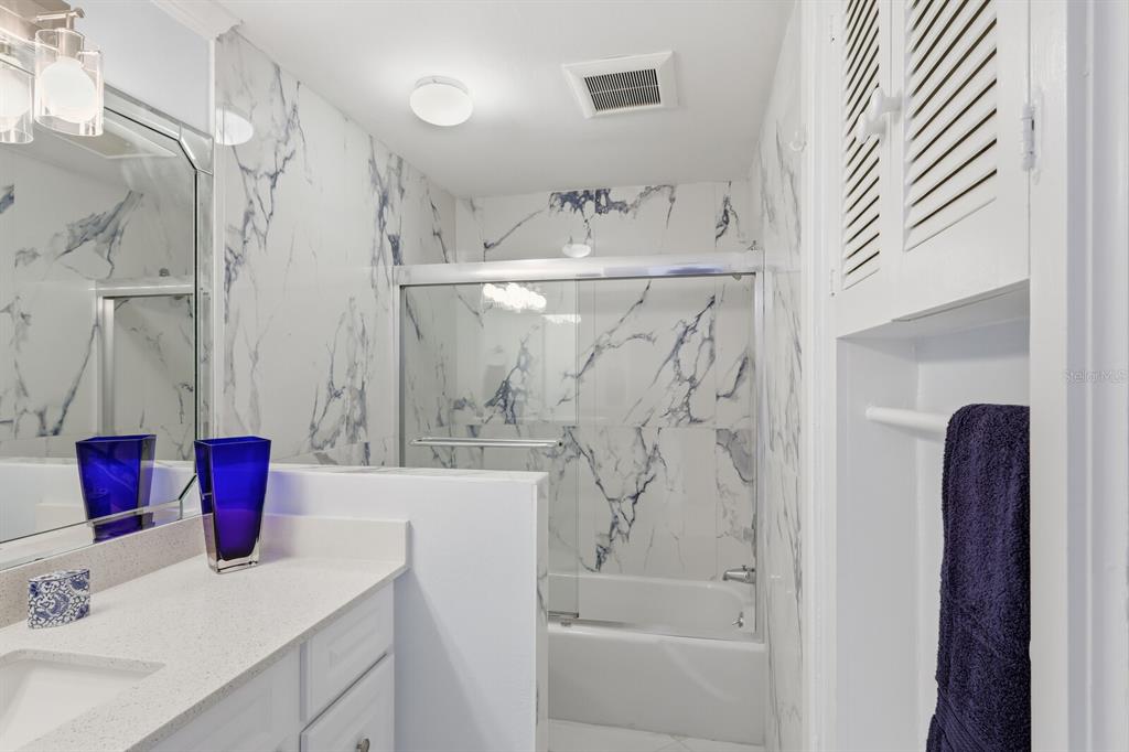 957 Spanish Drive North Longboat Key, FL 34228 - Photo 24 of 37 a bathroom with a bathtub sink vanity and shower