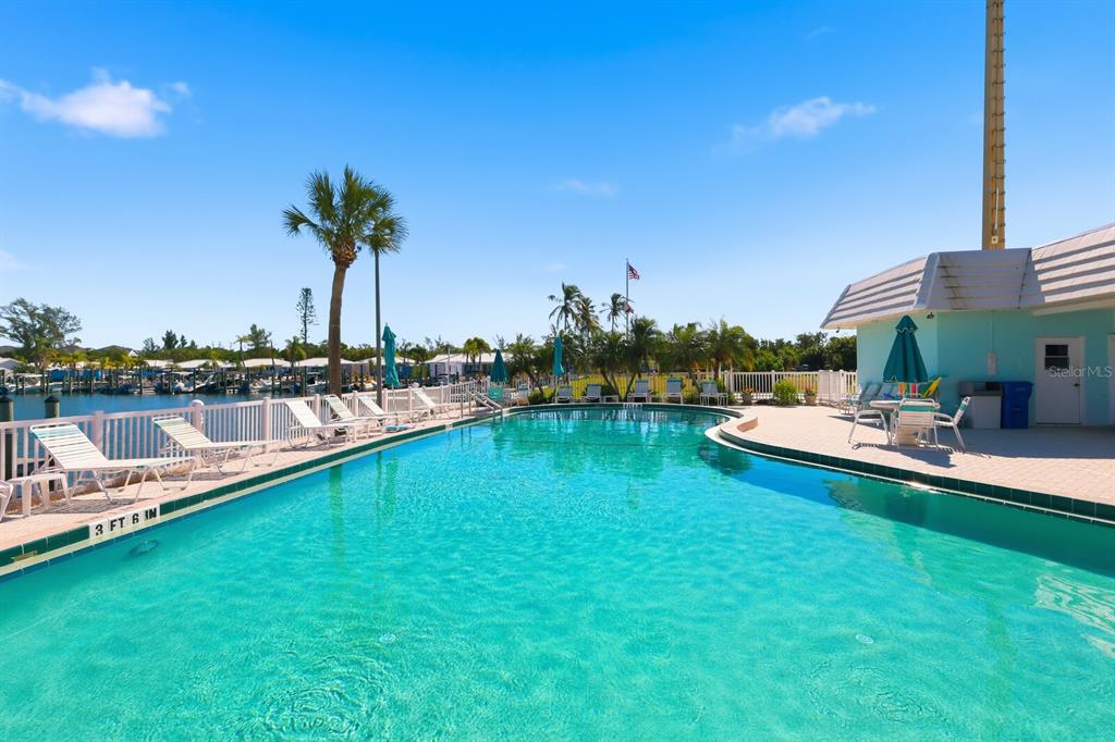 957 Spanish Drive North Longboat Key, FL 34228 - Photo 27 of 37 a view of a swimming pool with a table and chairs