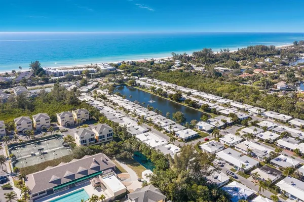 an aerial view of a city with ocean view in back