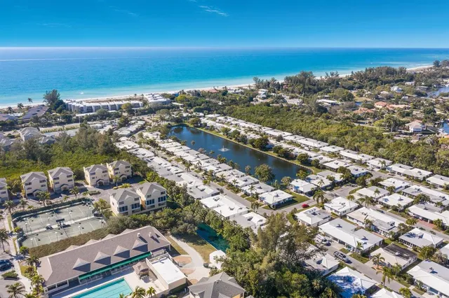 an aerial view of a city with ocean view in back