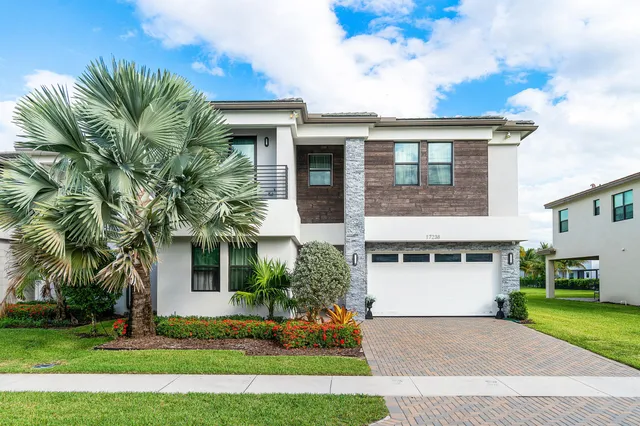 a front view of a house with a yard and a garage