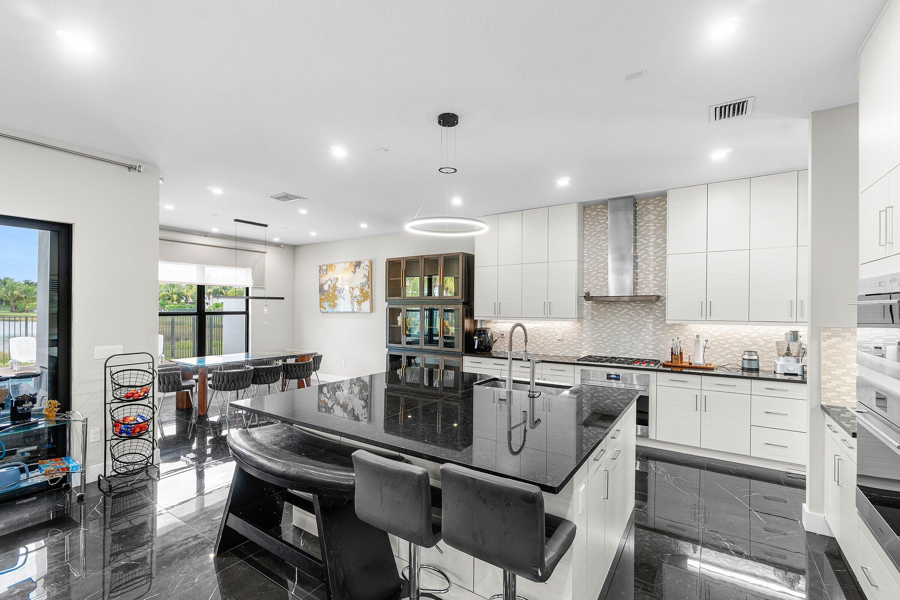 17238 Teton River Road Boca Raton, FL 33496 - Photo 11 of 67 a kitchen with a dining table chairs sink and cabinets