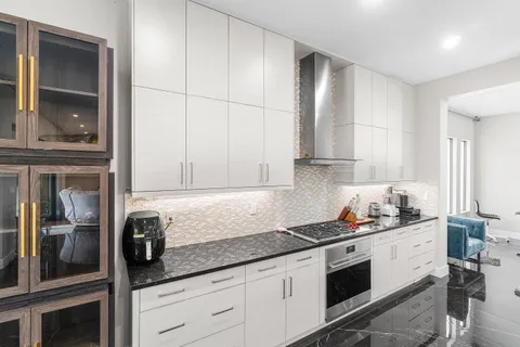 a kitchen with stainless steel appliances kitchen island granite countertop a refrigerator and microwave