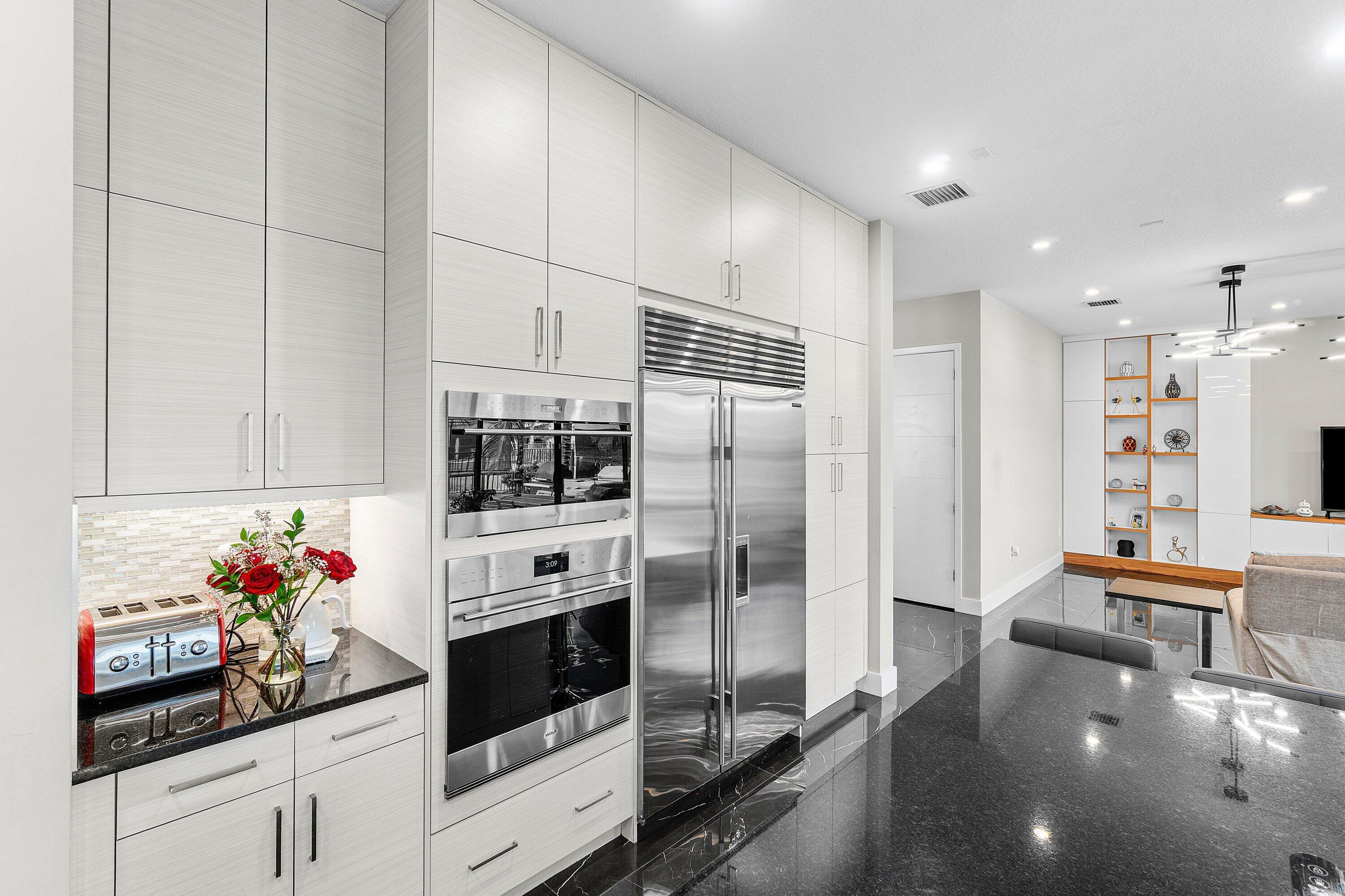 17238 Teton River Road Boca Raton, FL 33496 - Photo 14 of 67 a kitchen with stainless steel appliances kitchen island granite countertop a refrigerator and microwave
