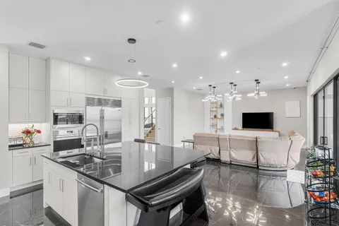a living room with furniture kitchen view and a large window