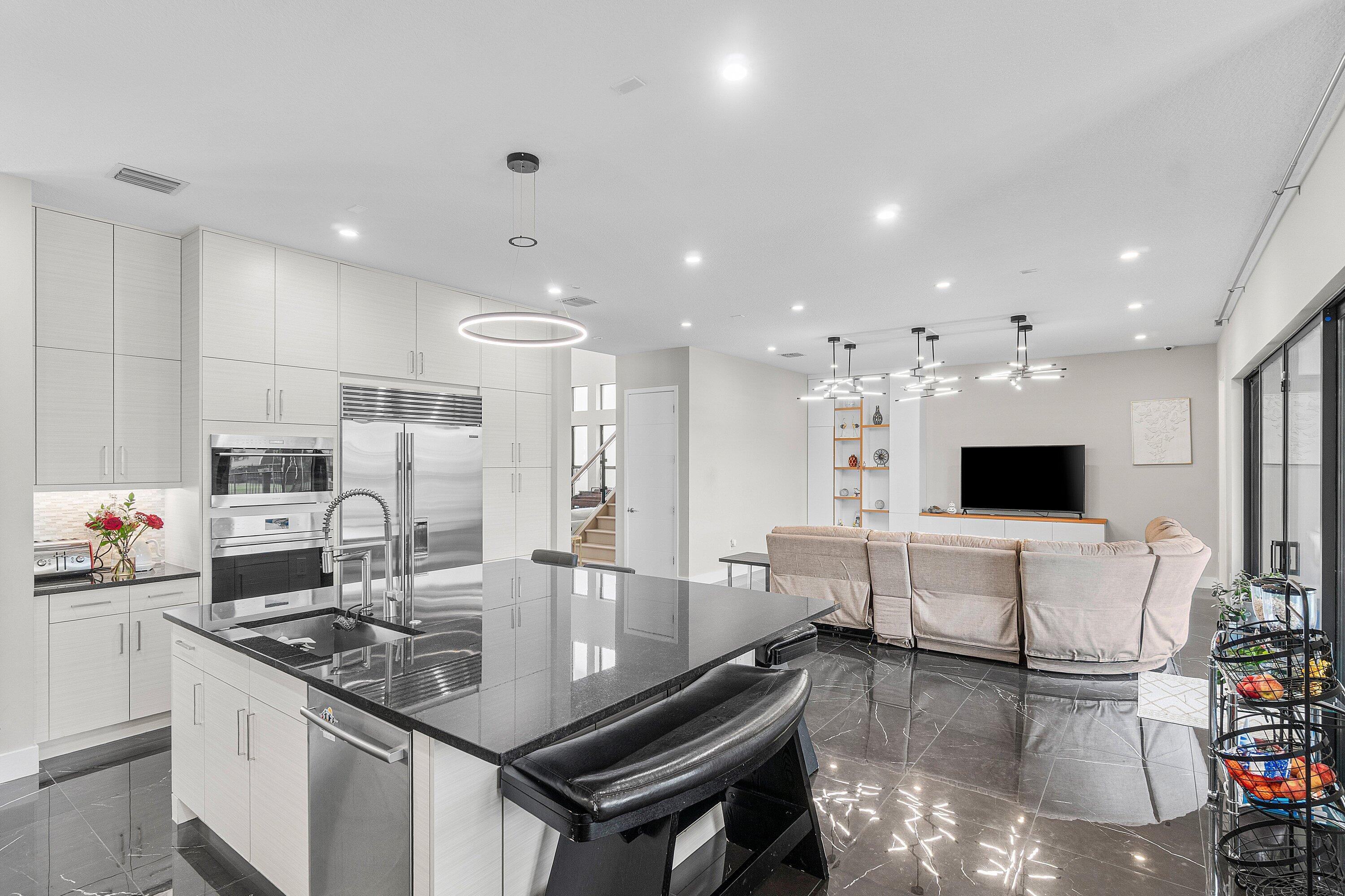 17238 Teton River Road Boca Raton, FL 33496 - Photo 17 of 67 a room with stainless steel appliances kitchen island granite countertop a sink and white cabinets