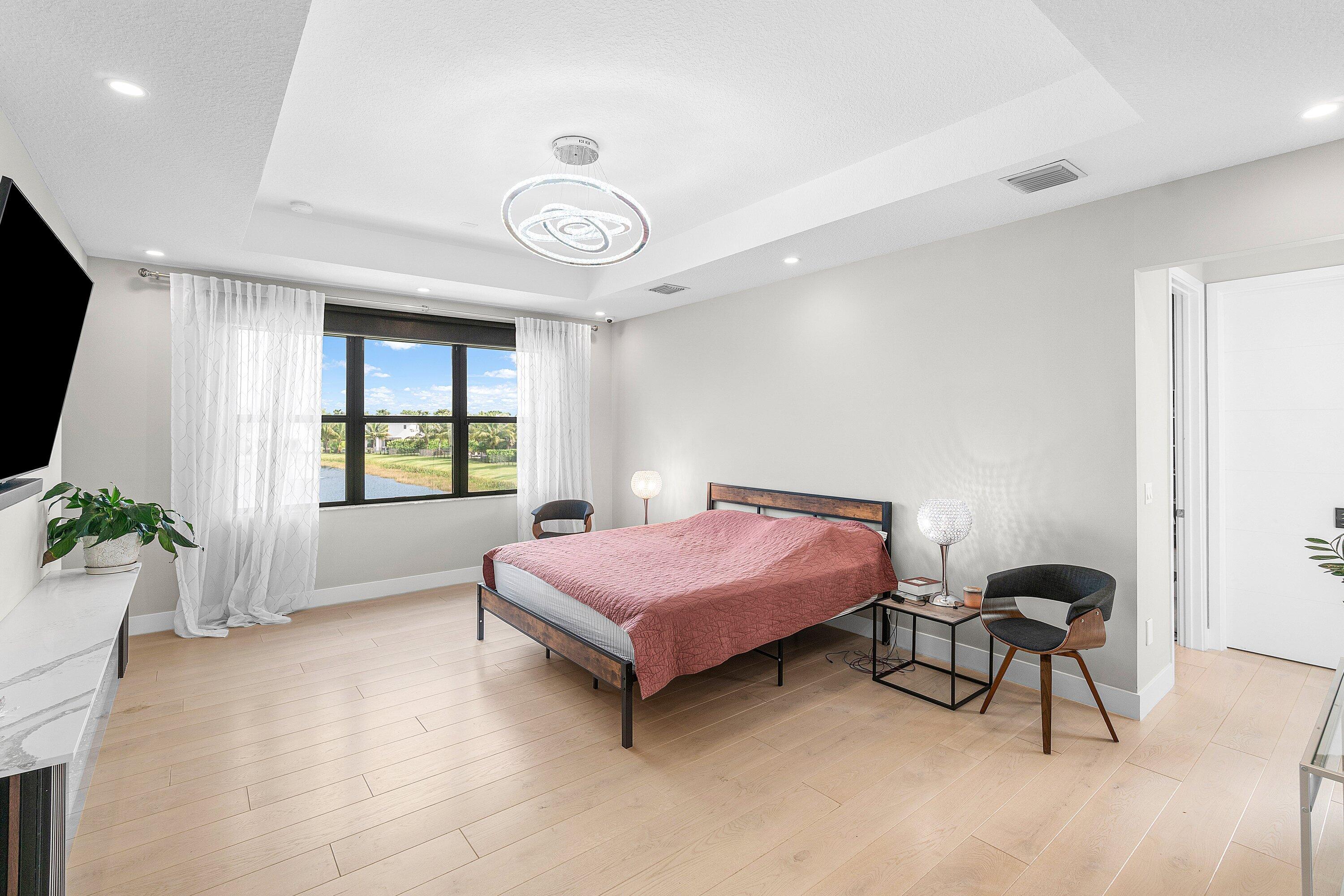 17238 Teton River Road Boca Raton, FL 33496 - Photo 25 of 67 a spacious bedroom with a bed and a chandelier