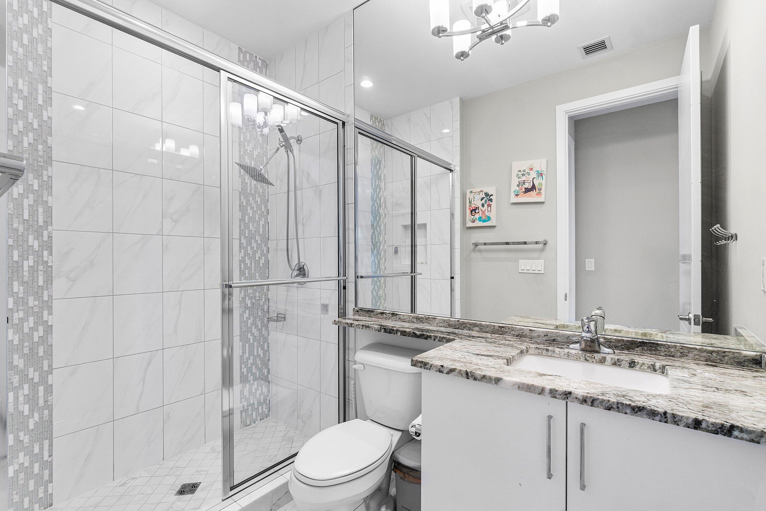 17238 Teton River Road Boca Raton, FL 33496 - Photo 39 of 67 a bathroom with a granite countertop sink a toilet and shower