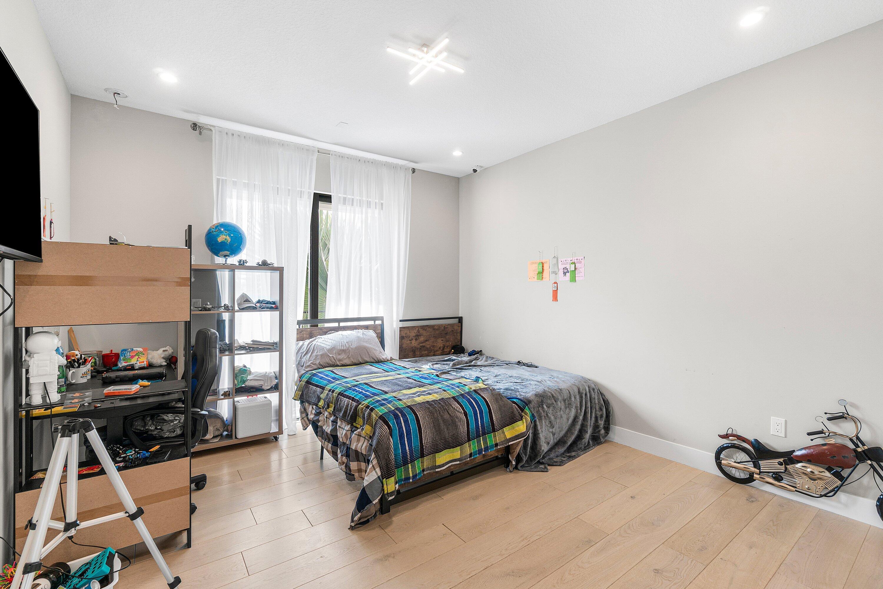 17238 Teton River Road Boca Raton, FL 33496 - Photo 40 of 67 a bedroom with a bed and a chandelier