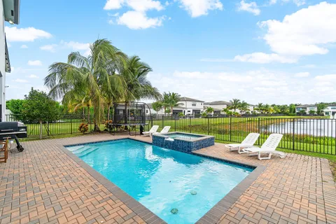 a view of a house with pool and sitting area