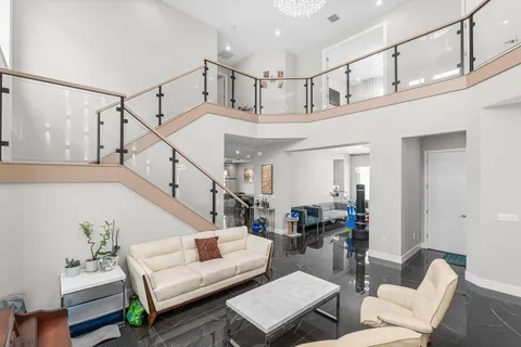 a view of staircase with white walls and a chandelier
