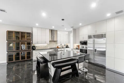 a kitchen with granite countertop stainless steel appliances a sink stove and cabinets