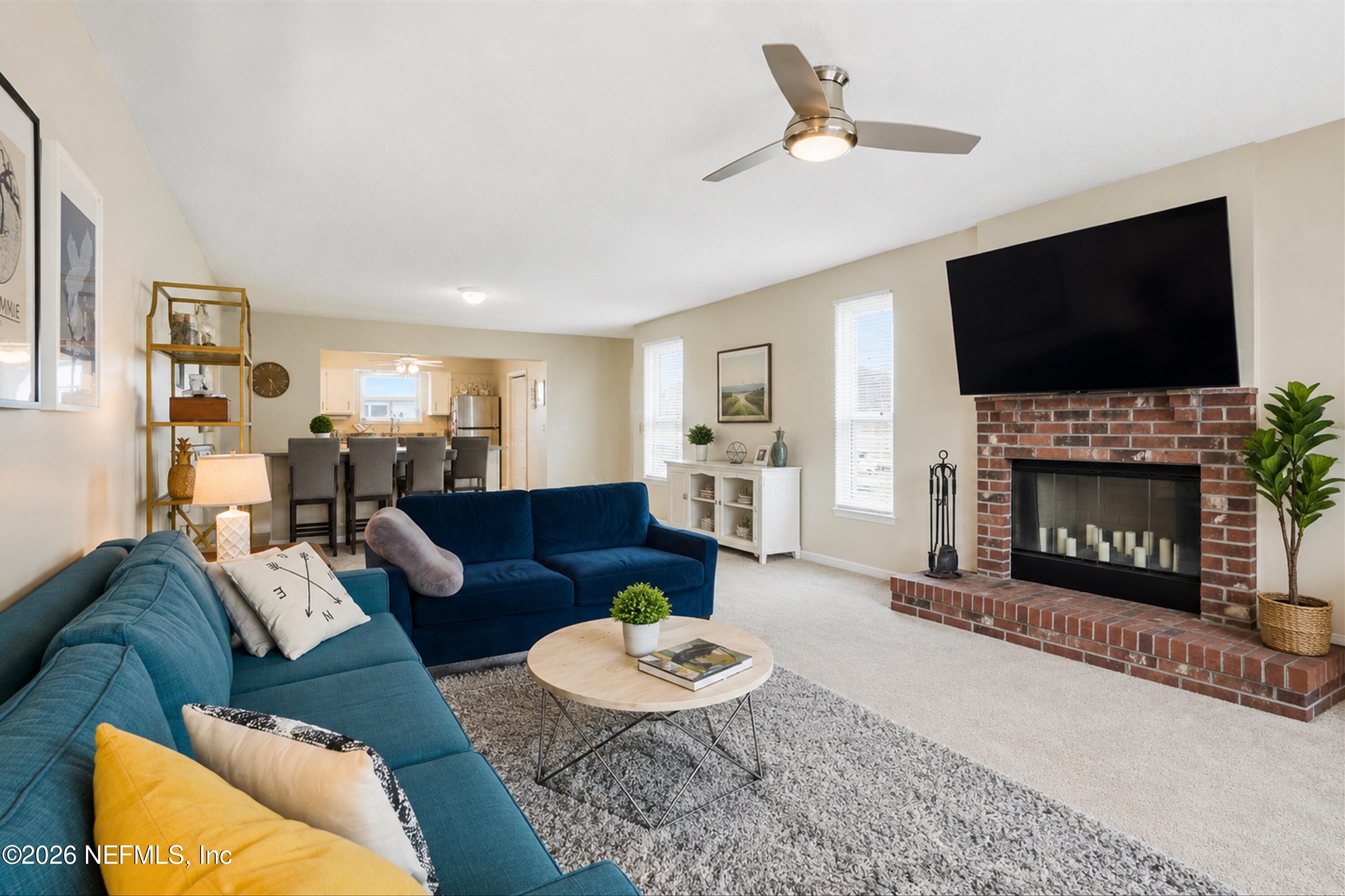 124 Hopkins Street Neptune Beach, FL 32266 - Photo 6 of 44 a living room with furniture a flat screen tv and a fireplace