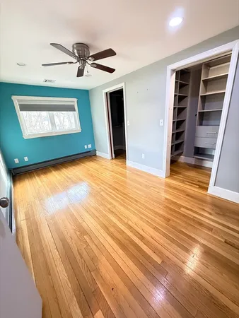 a view of an empty room with a window and wooden floor