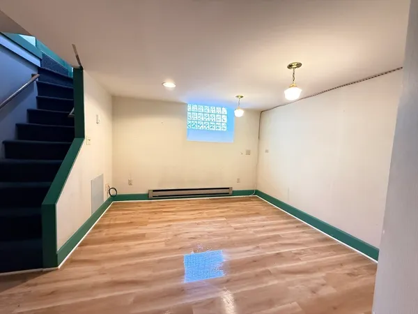 a view of a room with wooden floor and white walls