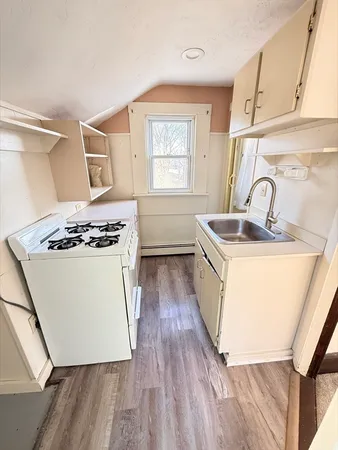 a kitchen that has stainless steel appliances a sink a stove and wooden floor