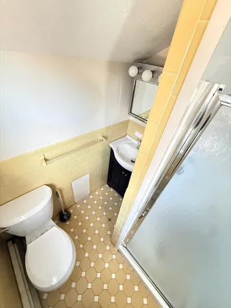 a bathroom with a toilet sink and mirror