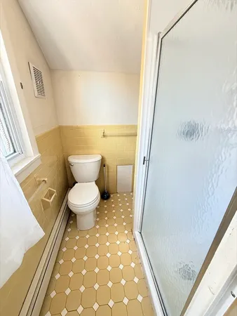 a bathroom with a toilet and a shower