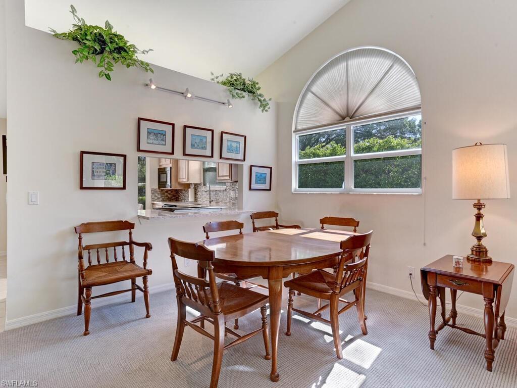 15335 Wimborne Lane Naples, FL 34110 - Photo 14 of 33 a dining room with furniture a rug and a large window
