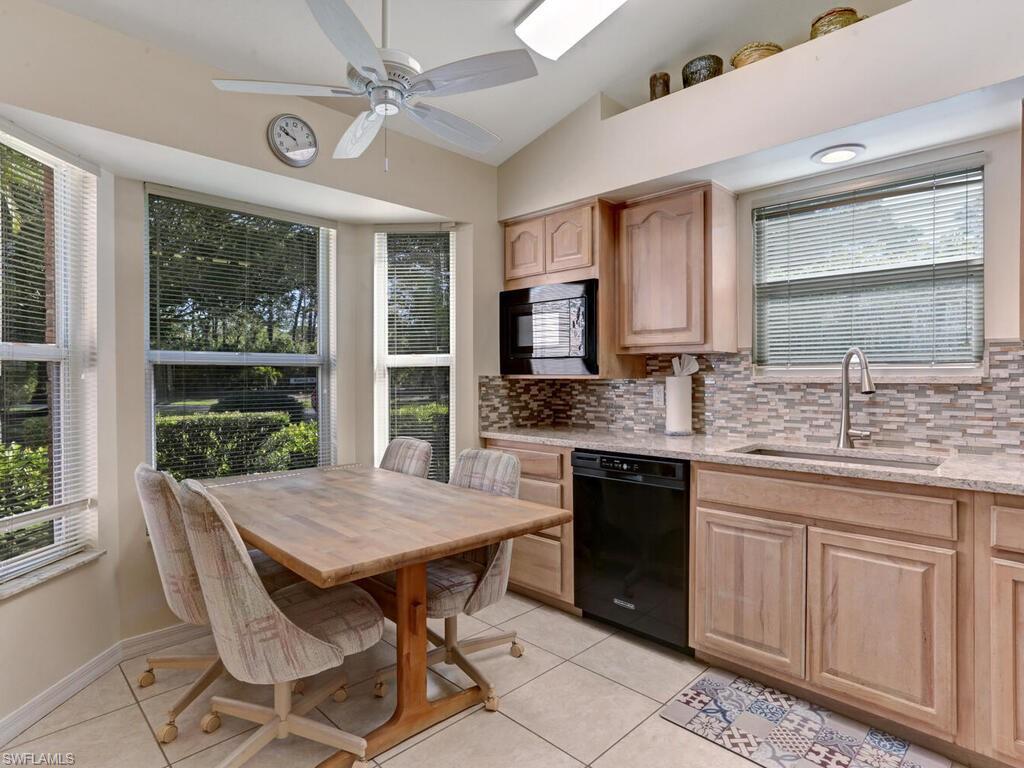 15335 Wimborne Lane Naples, FL 34110 - Photo 16 of 33 a kitchen with a table chairs sink and cabinets