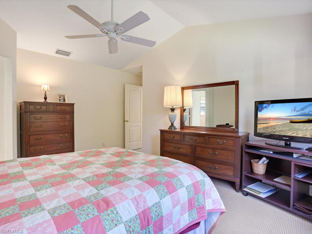 15335 Wimborne Lane Naples, FL 34110 - Photo 21 of 33 a bedroom with a bed and a dresser
