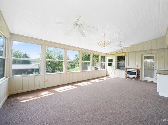 an empty room with furniture and large windows
