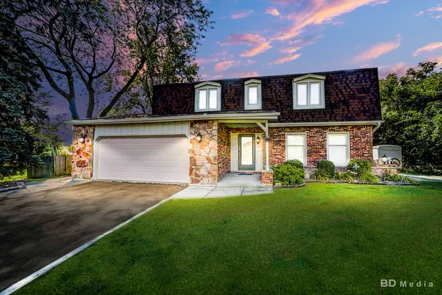 a front view of a house with a yard and trees