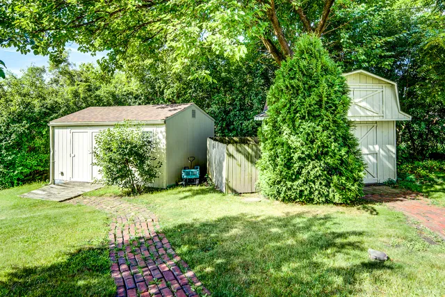 a view of a house with a yard and potted plants