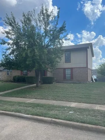 a view of a yard in front of a house with large trees