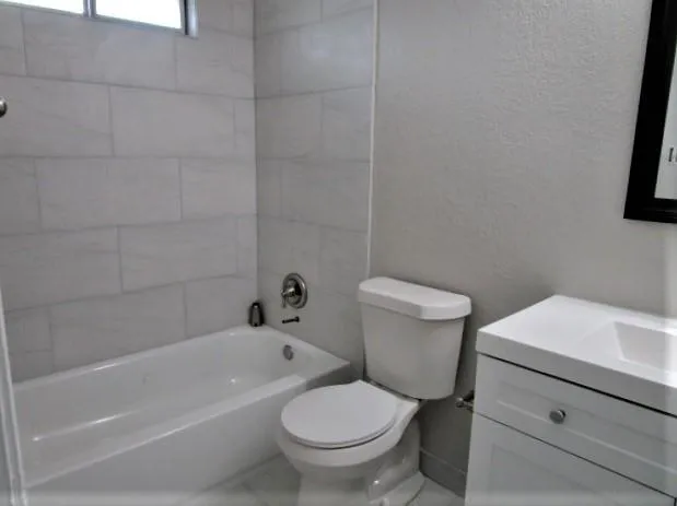a white toilet sitting next to a bath tub