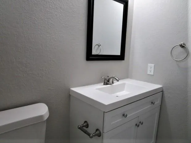 a bathroom with a toilet sink and mirror