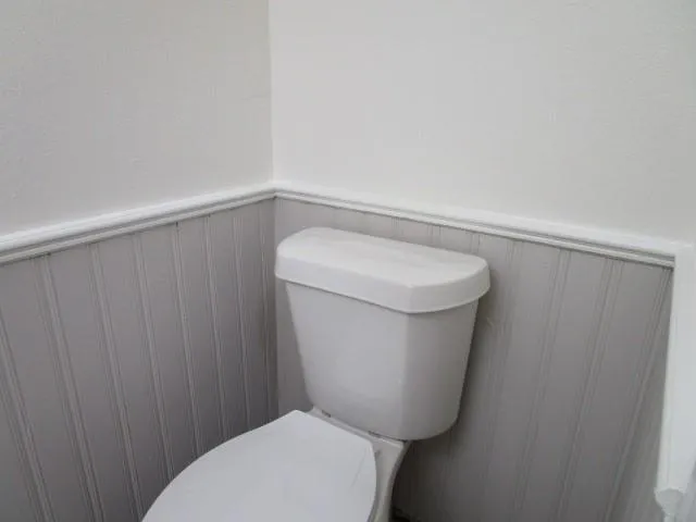a white toilet sitting next to a shower