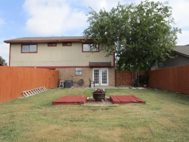 a view of a house with backyard and trees
