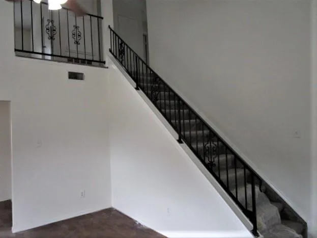 a view of staircase with wooden floor and white walls
