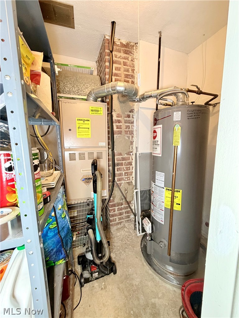32125 Densmore Road Willowick, OH 44095 - Photo 23 of 23 Utility closet featuring exposed brick, a water heater, and a furnace with visible ductwork